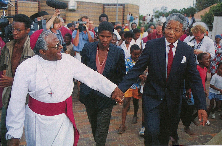 Two of SA’s Nobel Peace Prize laureates, former president Nelson Mandela and Archbishop Emeritus Desmond Tutu, join hands in Ipeleng, White City, Soweto, circa 2000.