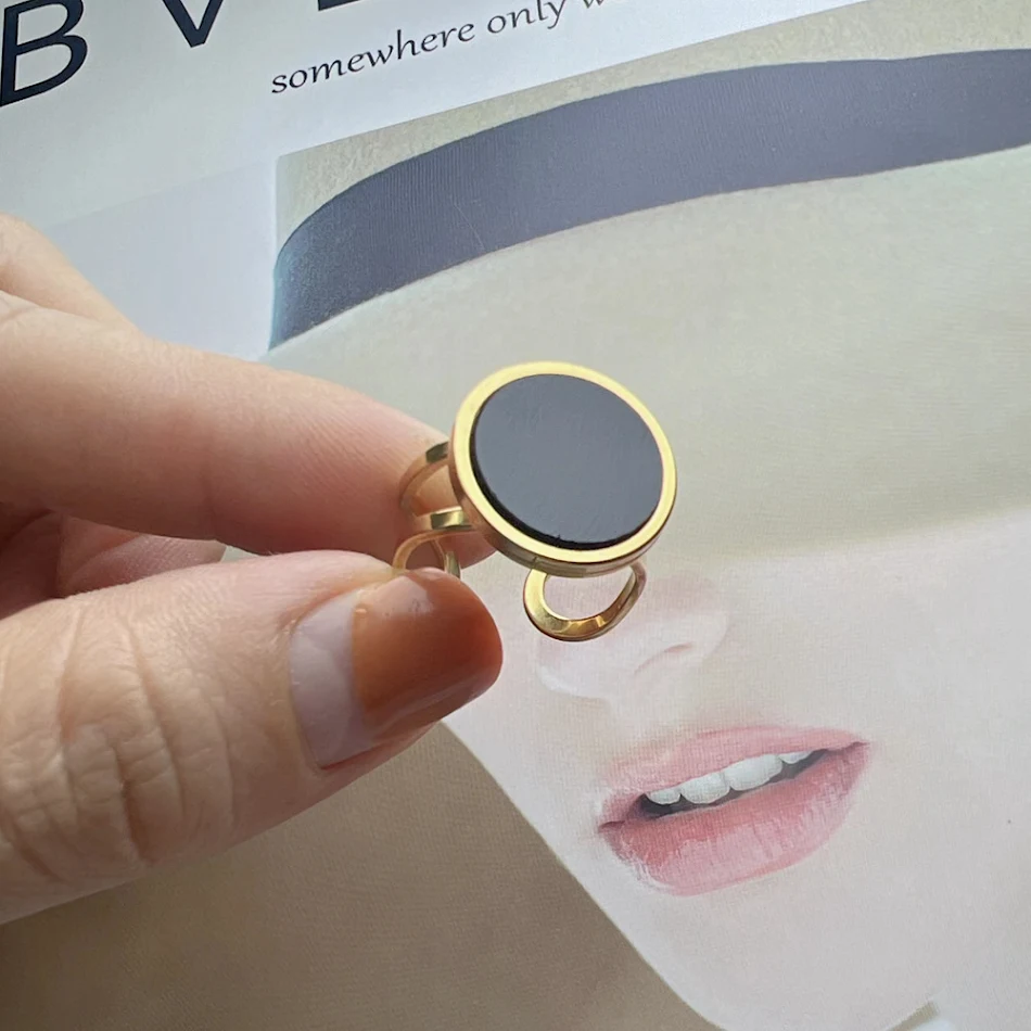 Bague en coquillage blanc et agate noire en acier inoxydable doré avec ouverture. Un bijou élégant et ajustable pour femme.