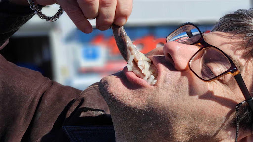 Fish face: Enjoying haringhappen, the Dutch delicacy of raw herring.