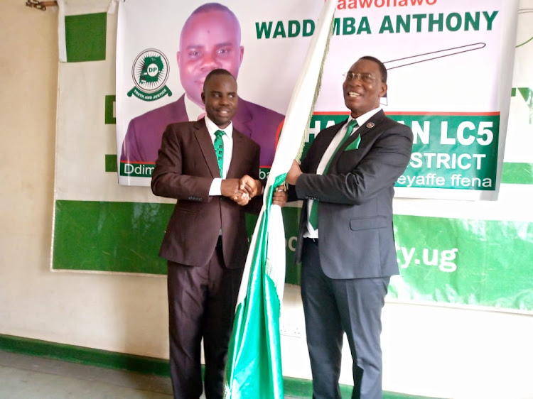 George Kagimu DP Vice Chairman for Buganda region handing over the party flag to Waddimba Anthony