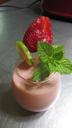 Healthy yummy smoothie! Garnished with a cucumber wedge, mint and a strawberry on a straw! LOL