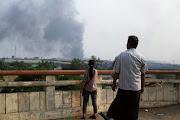 People look at smoke believed to be from a factory fire during the security force crackdown on anti-coup protesters at Hlaingthaya, Yangon, Myanmar, on March 14 2021. 