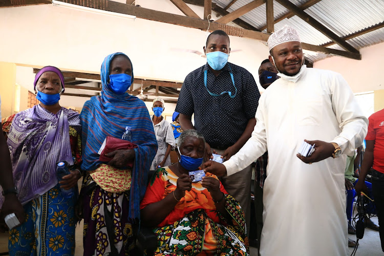 Jomvu MP Badi Twalib [R] issues NHIF cards to 1,700 elderly beneficiaries in Jomvu on Friday.