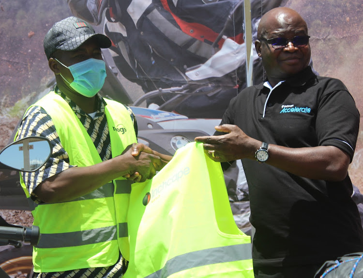 The chairman of boda boda riders in Nyeri Laban Nderitu receives a reflector jacket from Inchcape Africa managing director Francis Agbonlahor in Nyeri town on Saturday