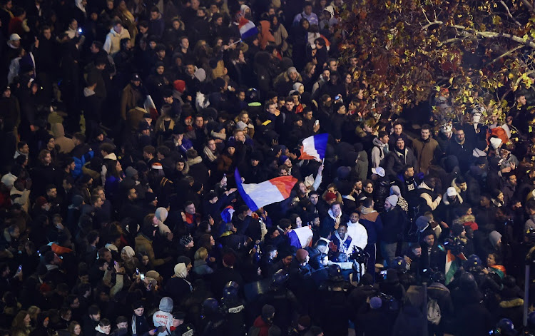 Fans celebrate on the Champs Elysees in Paris after France won their World Cup semifinal against Morocco on December 14 2022.