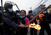 A police officer tries to stop a demonstrator during a torch rally as people protest against the dissolution of parliament in Kathmandu, Nepal. 