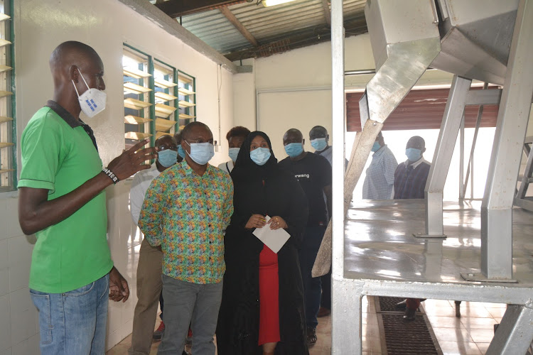 James Oduor, a manager at Malindi juice factory, takes Kilifi Governor Amason Kingi and other officials on a tour of the factory