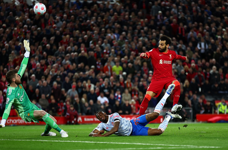 Mohamed Salah scores Liverpool's fourth goal while under pressure from Aaron Wan-Bissaka of Manchester United in the Premier League match at Anfield on April 19 2022.