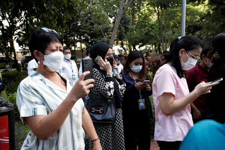 People gather as they are evacuated outside a building following an earthquake in Jakarta, Indonesia, November 21, 2022.