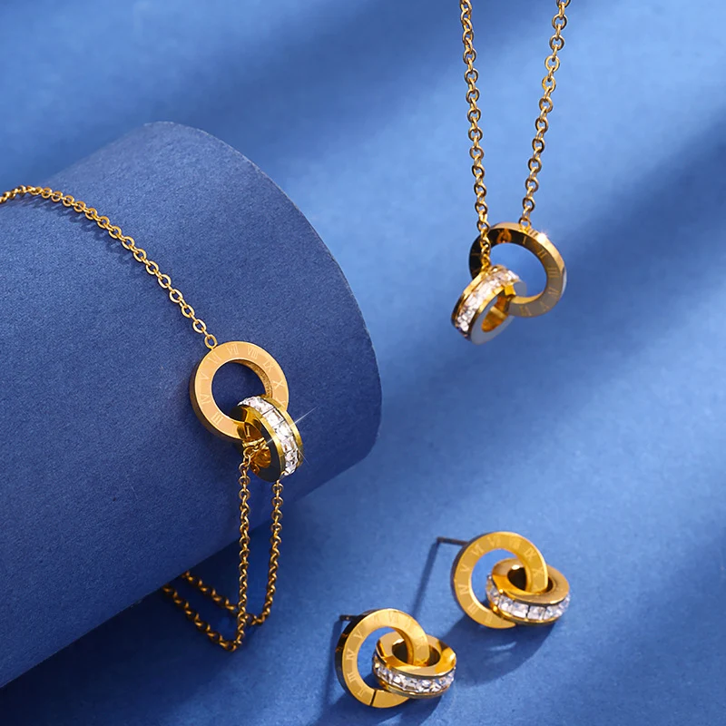 Ensemble de trois pièces tendance, comprenant bracelet, collier et clous d'oreilles avec double anneau. Accessoire parfait pour toutes occasions.