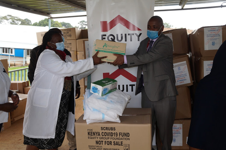 Kiambu county Covid-19 centre medical officer Caroline Mwangi receives donations from Equity Foundation through Equity Bank Limuru branch Joseph Weru on Monday.