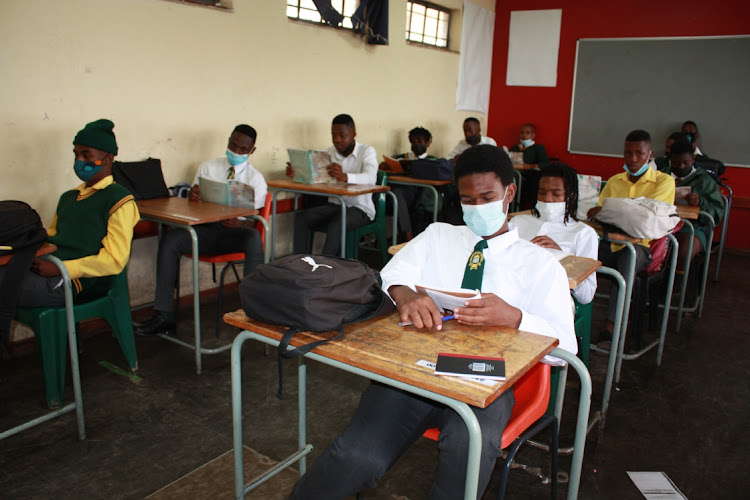 Grade 12 pupils of Lehabile Secondary school in Mamelodi reading their books on their first day back at school.