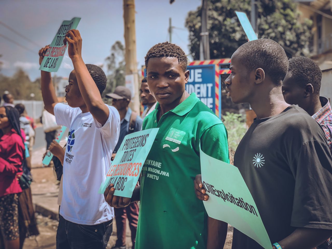 Three men hold protest placards in the street