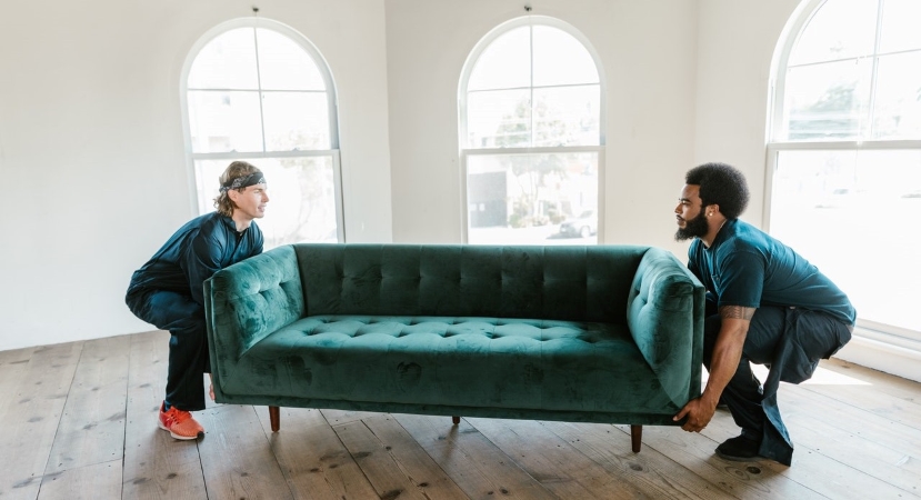 two men lift a couch during a move