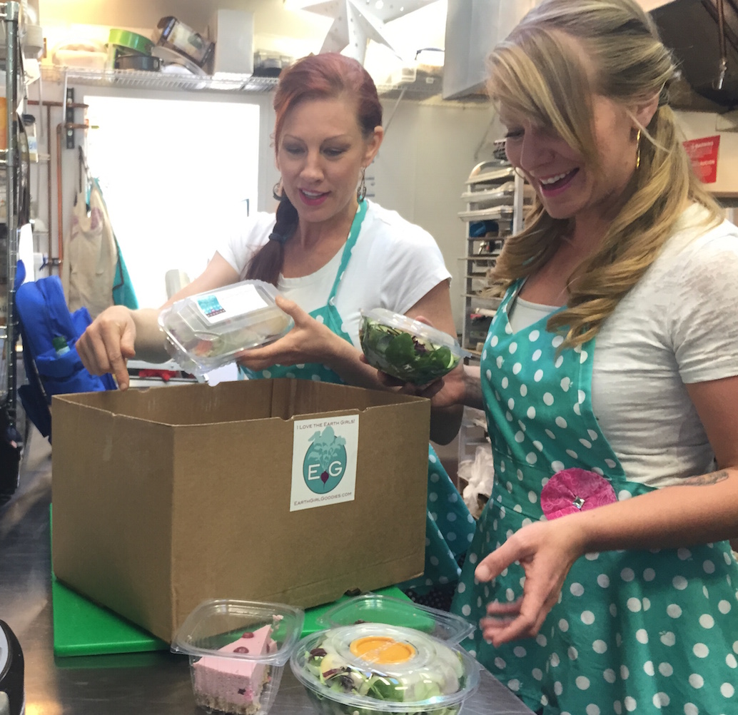 Kirsten and Emyrald filling a Goodie Box with delicious pre-made meals.