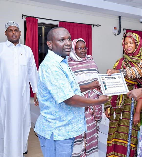 Garissa county health executive Roble Nunow awards Lucy Gatui as the best performing mentor in emONC mentorship 2022