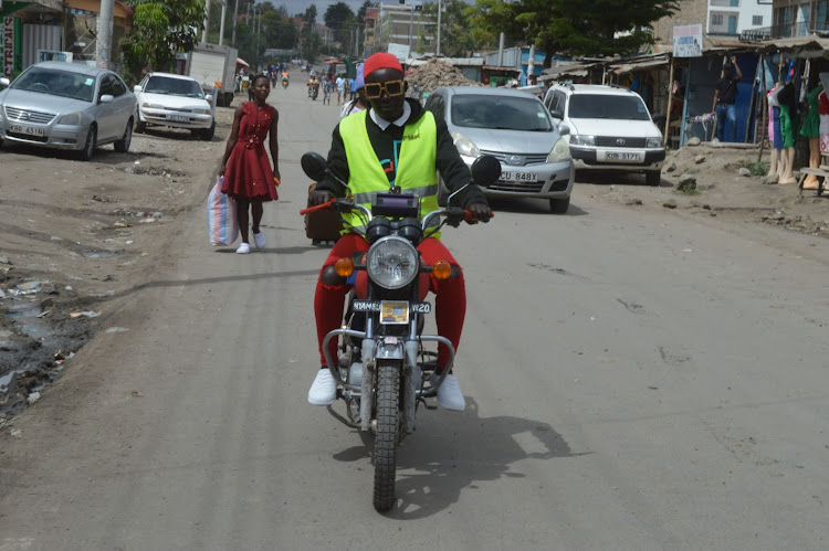 Boda boda rider Consolata Adipo rides her boda boda in Athi River, Machakos county