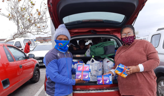 Godfrey Jacobs receives toiletries from Onele Mazwi for his initiative to help vulnerable children