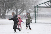 From left: Alex Grobler and Sisters Onalenna and Thoriso Monama play in the snow, 10 July 2023, at Jackson Dam in Alberton, South of Johannesburg.   