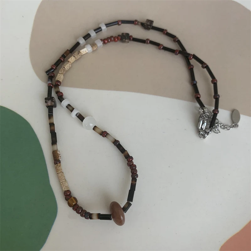 Colar artesanal chinês retrô marrom com contas de pedra e madeira, design de nicho. Um acessório elegante e exclusivo para complementar seu estilo.