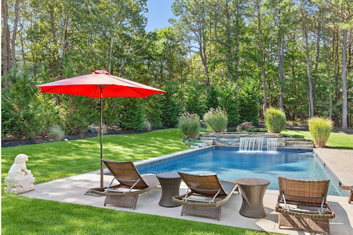 Pool with waterfall and lounge chairs - Buy this luxury property in East Quogue, 4 bedrooms