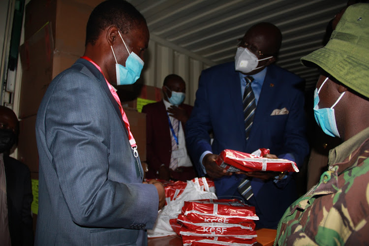 Education CS George Magoha hands over exam papers to Homa Bay Boys High School principal Vincent Mayienga in Homa Bay town on April 7, 2021.