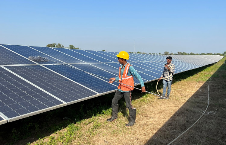 Workers clean panels at a solar park in Modhera in the western state of Gujarat, India. File photo: REUTERS/SUNIL KATARIA