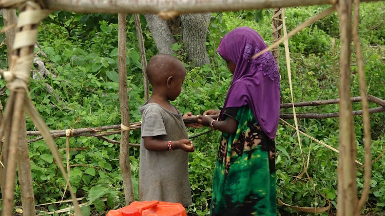 Children help their parents build makeshift shelter at their IDP Camp located at Centre near Garsen town of Tanadelta in tanariver County