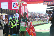 Comrades Marathon winner Edward Mothibi celebrates with the trophy after winning the men's race for the first time on June 9 2019. 