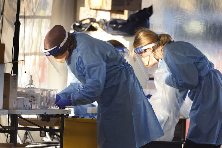 Medical workers are seen at a 24-hour Covid-19 testing clinic in Fairfield West on July 18, 2021 in Sydney, Australia.