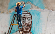 A Palestinian artist paints a mural depicting George Floyd in Gaza City on June 16. 