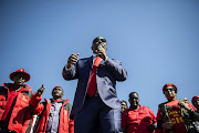 South African opposition party Economic Freedom Fighter ( EFF) leader Julius Malema (C) addresses his supporters after his corruption trial was postponed on August 3, 2015 outside the High Court in Polokwane. Photo Credit: MUJAHID SAFODIEN/AFP