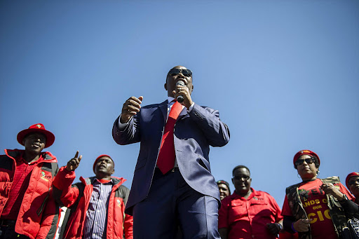 South African opposition party Economic Freedom Fighter ( EFF) leader Julius Malema (C) addresses his supporters after his corruption trial was postponed on August 3, 2015 outside the High Court in Polokwane. Photo Credit: MUJAHID SAFODIEN/AFP