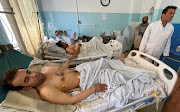 Wounded Afghan men receive treatment at a hospital after explosions outside the airport in Kabul, Afghanistan on August 27, 2021. The writer says China will be one of the winners coming out of this human tragedy that is now unfolding.