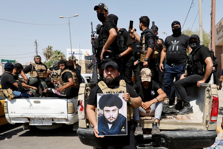 Followers of Iraqi cleric Muqtada al-Sadr withdraw from the streets after violent clashes, near the Green Zone in Baghdad, Iraq, August 30 2022. Picture: AHMED SAAD/ REUTERS