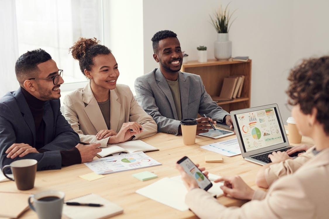 Employees gathered in a table, discussing something with smiles on their faces