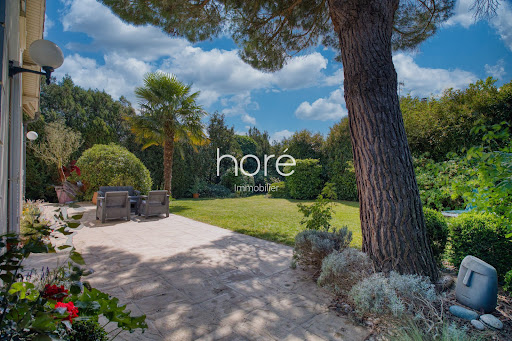 Stone patio with garden furniture, lawn, trees in this luxury house for sale in Montmorency ($1,035,948 - 195 m²)