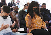 Charl Kinnear's wife, Nicolette, during his memorial service outside their house in Bishop Lavis where he died in a hail of bullets on Friday afternoon. Beside her is her son Carlisle.