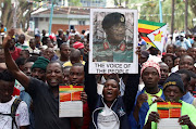 A protester holds up a poster of Zimbabwean armed forces commander Constantino Chiwenga, outside the parliament in Harare, Zimbabwe, on November 21, 2017. Picture: REUTERS