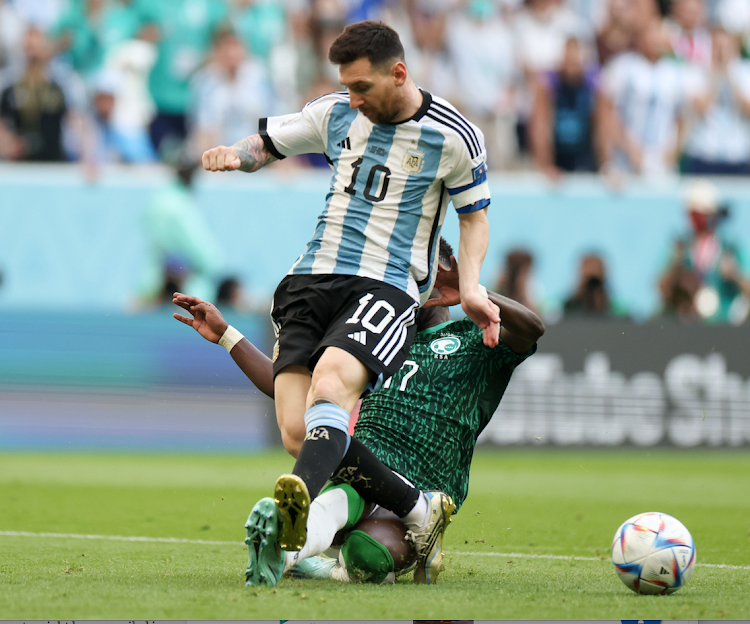 Lionel Messi of Argentina vies with Hassan Altambakti of Saudi Arabia during the Group C match at the 2022 FIFA World Cup at Lusail Stadium in Lusail, Qatar