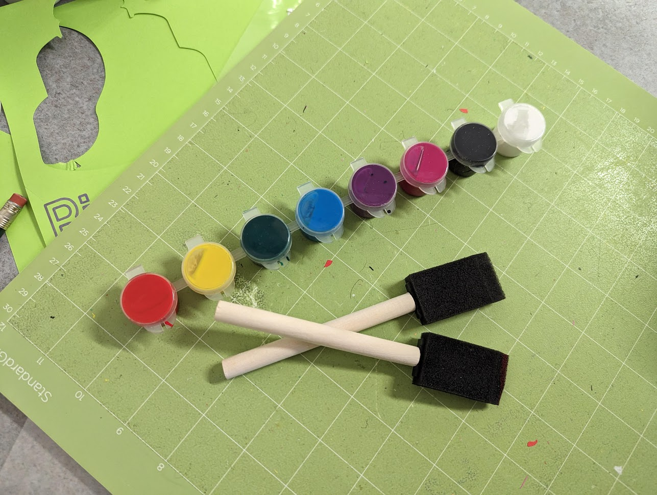 close-up photo of two paintbrushes and an array of paints