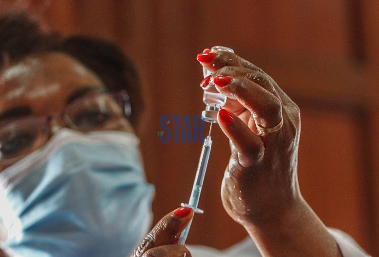 A Ministry of Health staffer holds the AstraZeneca Covishield Vaccine before vaccinating a staff at the Milimani law Court on Mach 24, 2021.