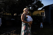 Widowed Lindsay Myeni carries her six-month-old baby, Nandi Lindeni, at her husband's eSikhawini home in northern KwaZulu-Natal.