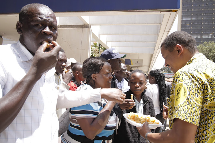 Amnesty International Executive Director Houghtoun Irungu distributes cake to members of the public during a memorandum of state agencies responsible for the administration of justice on the tenth anniversary of Amnesty International Kenya at Aga Khan Walk on October 12, 2022.