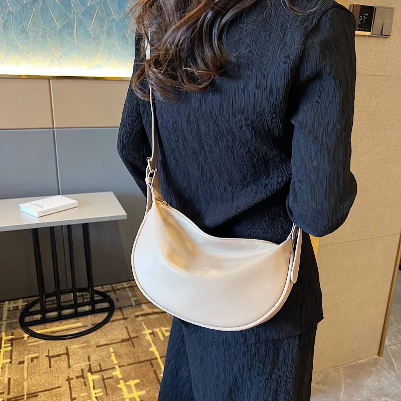 Sac à bandoulière petit format en forme de croissant de lune, couleur unie. Élégant et pratique, parfait pour transporter l'essentiel au quotidien.