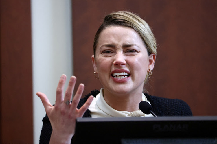 Actor Amber Heard reacts on the stand in the Fairfax County Circuit Court during a defamation case against her by her ex-husband, actor Johnny Depp.