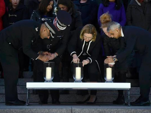 Britain's Home Secretary Amber Rudd and London Mayor Sadiq Khan light candles at a vigil in Trafalgar Square the day after an attack, in London, Britain March 23, 2017. /REUTERS