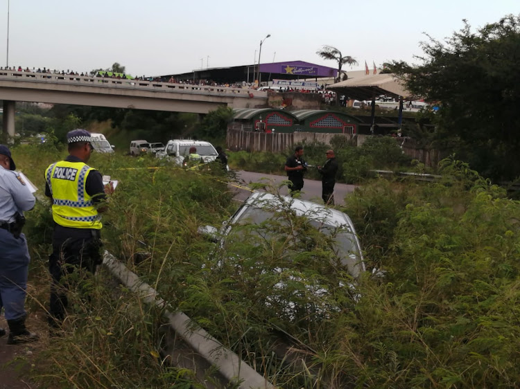 A Metro police officer at the scene where Inspector Nhlanhla Maphumulo was shot countless times and was found slumped in the driver's seat of his vehicle on the R102, north of Durban, on Monday.