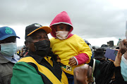 ANC President, Cyril Ramaphosa takes pictures with a child wearing an ANC T-shirt during his campaign at Intabazwe Community Staduim in Maluti A Phofung in the Free State on Sunday.