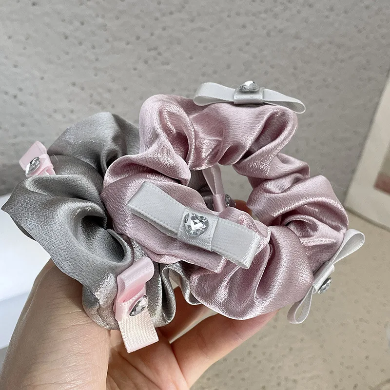 Anneau de cheveux en forme d'intestin épais avec nœud en satin pour femmes. Créez des coiffures sophistiquées et tendance avec cet accessoire.